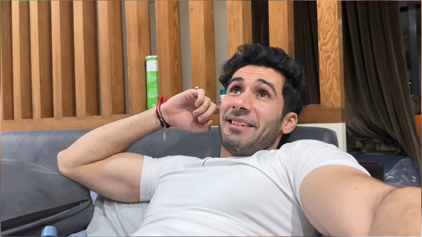 Siwet Tomar relaxing on a couch, smiling casually while wearing a white t-shirt indoors