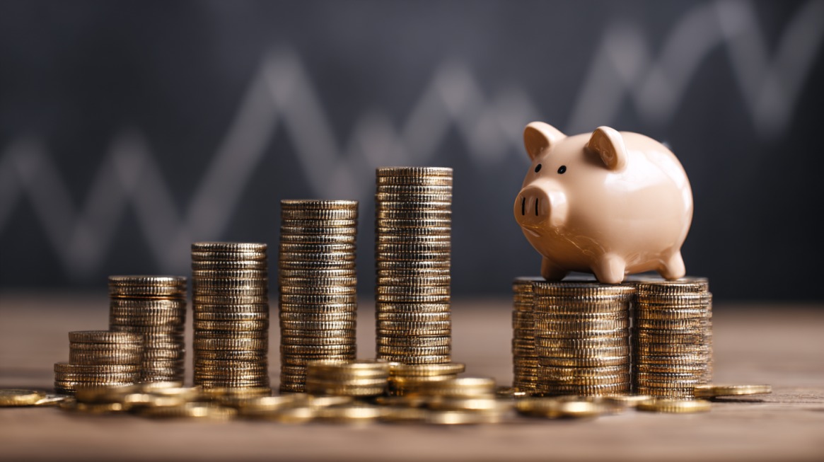 Piggy bank on stacked coins with increasing height, symbolizing financial growth