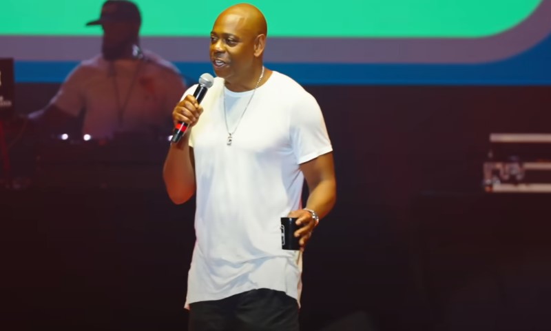 Dave Chapelle talking on a stage during a standup