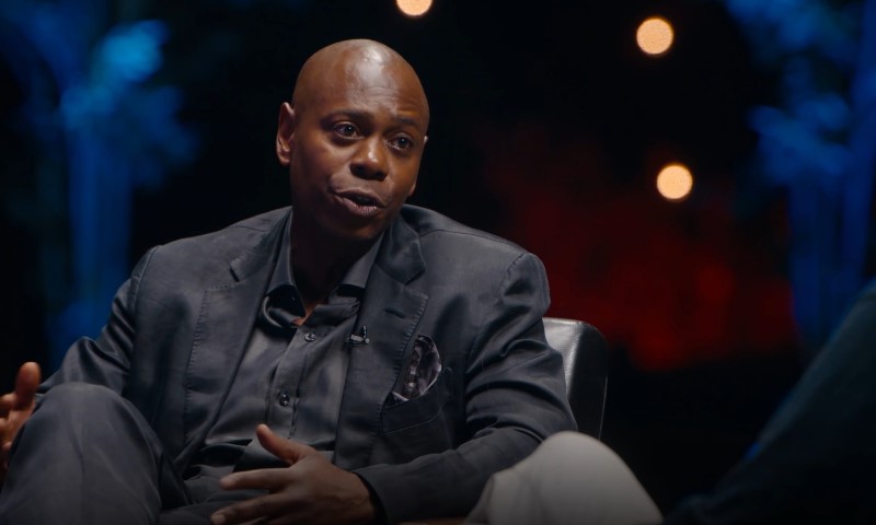Dave Chapelle talking with a TV host during a show