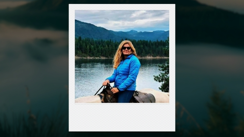 Hellen Willink outdoors in a blue jacket, sitting on a horse near a lake