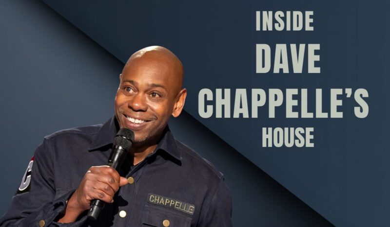 A close up of Dave Chapelle smiling while talking on microphone