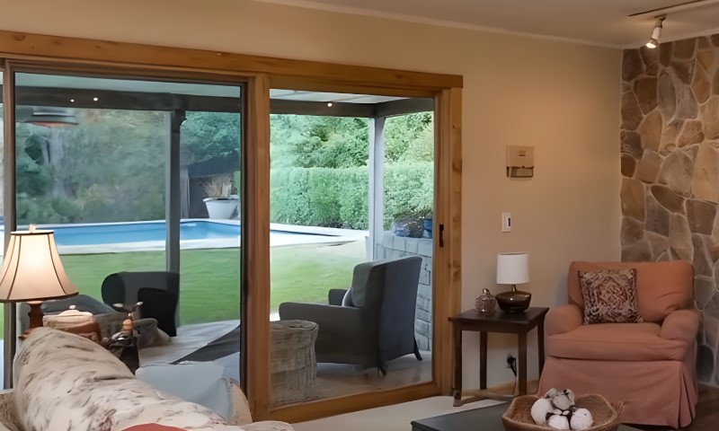 A cozy living room featuring a stone fireplace and large sliding glass doors that open to an outdoor space