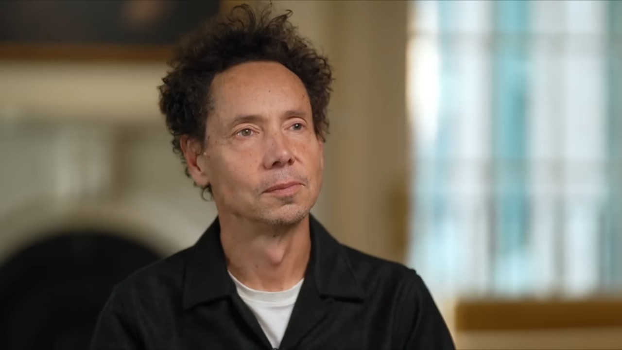 Malcolm Gladwell during an interview, looking thoughtful in a quiet setting