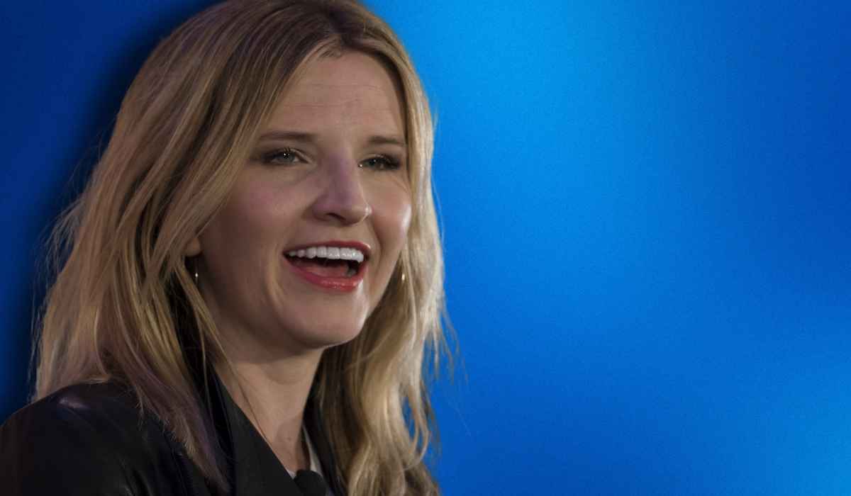 Tara Westover smiling against a blue background, known for her memoir Educated