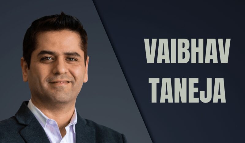 Vaibhav Taneja, Tesla CFO, photographed in a formal suit with a confident expression against a dark background
