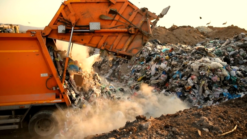 Garbage truck unloads mixed waste at a disposal site for recycling collection