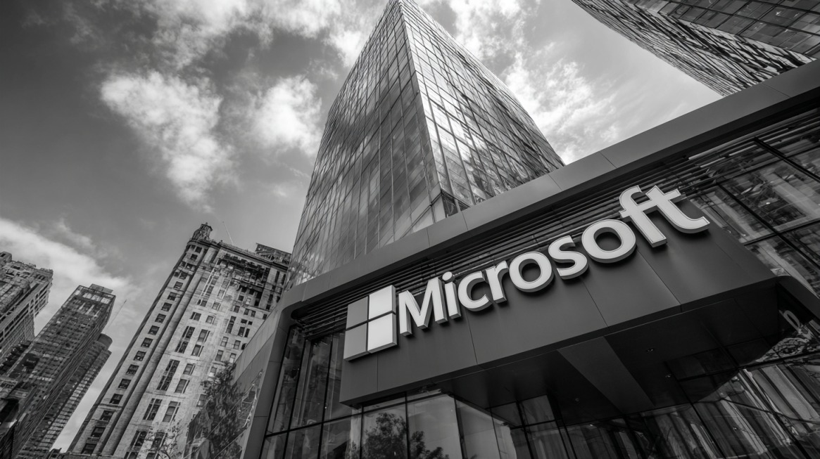 Microsoft logo on a modern glass building surrounded by tall city skyscrapers