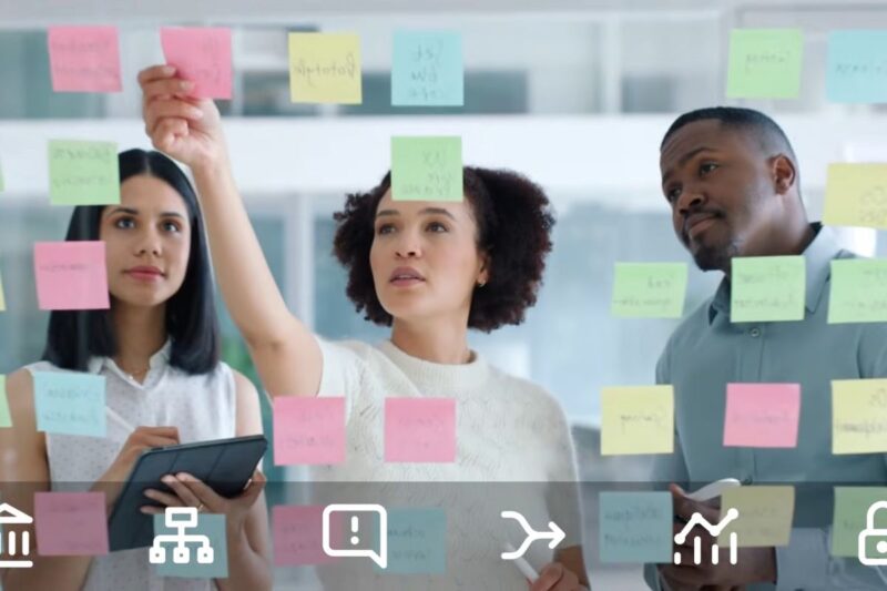 Team reviewing and categorizing data priorities using sticky notes on a glass board