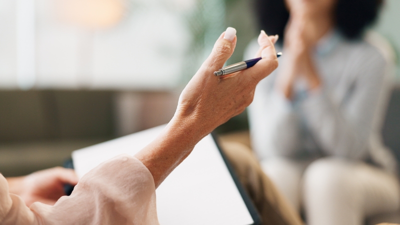 Consultant taking notes during a one-on-one professional counseling session