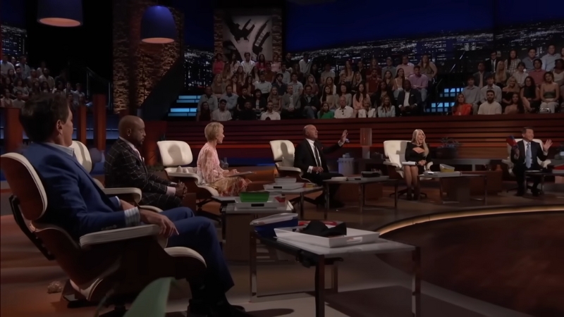 Sharks seated on the Shark Tank stage facing an entrepreneur during a pitch