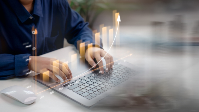 Person reviewing campaign performance data with rising ROI chart on a laptop screen