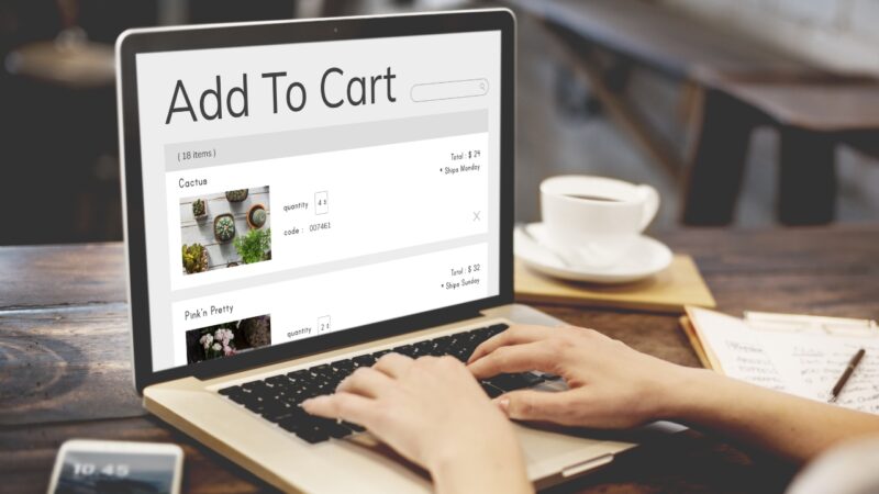Person adding items to an online shopping cart on a laptop