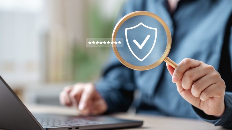A person checks website security with a shield icon and password field on a laptop