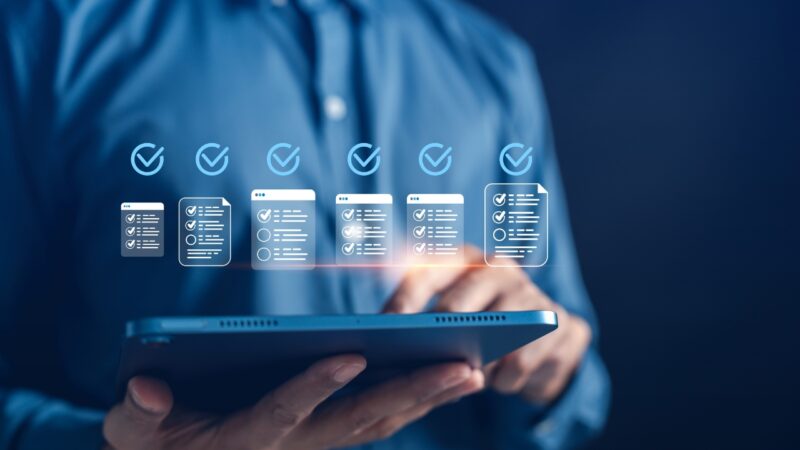 A person uses a tablet to manage digital workflow checklists